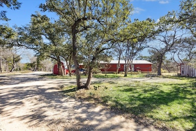 View of yard with an outbuilding, driveway, and f