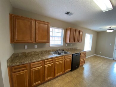 Kitchen featuring sink, light tile flooring, dishw