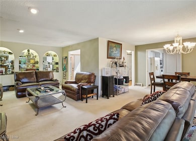 Living room with a chandelier, a textured ceiling, and carpet flooring