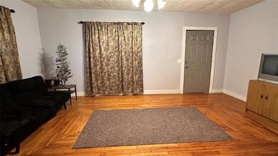 Living room featuring a textured ceiling, a notabl
