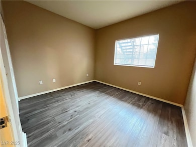 Spare room featuring dark wood-type flooring and b