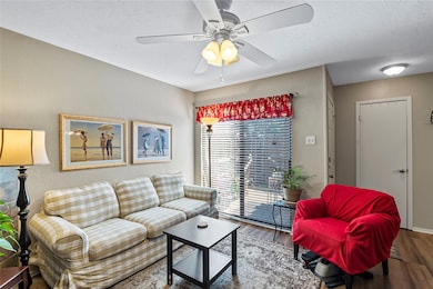 Living room featuring ceiling fan, wood-type floor