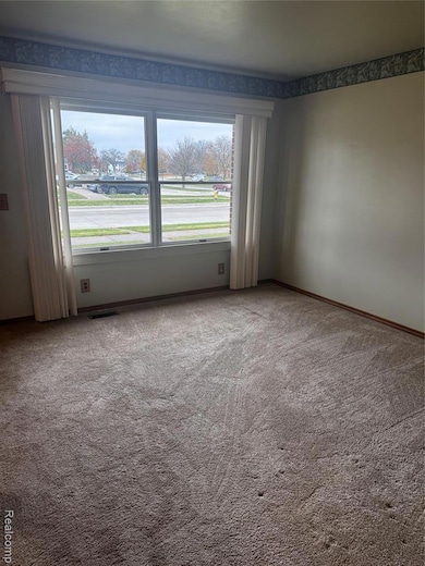 Carpeted empty room with baseboards