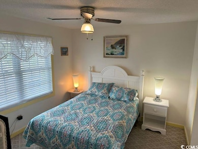 Carpeted bedroom with a textured ceiling and ceili