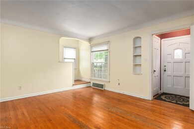 Foyer entrance to the front home, coat closet door visible behind the wall shelving. Nice hardwood floors, cove ceiling. The living room was freshly painted prior to listing!