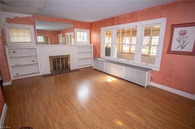 living room with wood flooring and a brick firepla