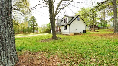 View of side of home with crawl space, fence, and a lawn