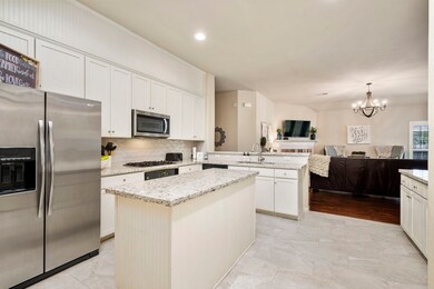 Recently updated kitchen includes granite counters, tile backsplash, SS appliances, and high-end tile flooring.