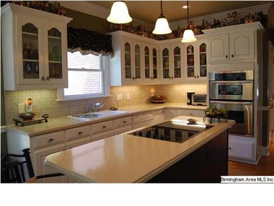 Kitchen with some glass cabinets and island