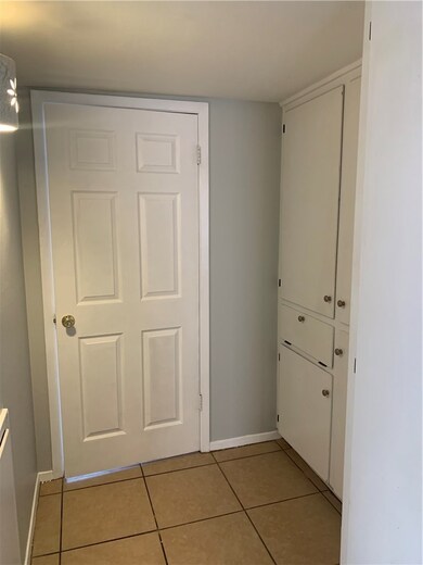 Hall with baseboards and light tile patterned floo