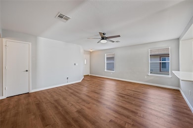 Empty room featuring wood finished floors, ceiling fan, and a textured ceiling
