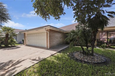 View of front facade featuring a garage, brick siding, and driveway