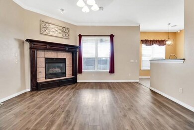 Unfurnished living room featuring a chandelier, wood finished floors, baseboards, plenty of natural light, and crown molding