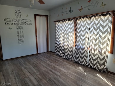 Unfurnished room with dark wood finished floors and a ceiling fan
