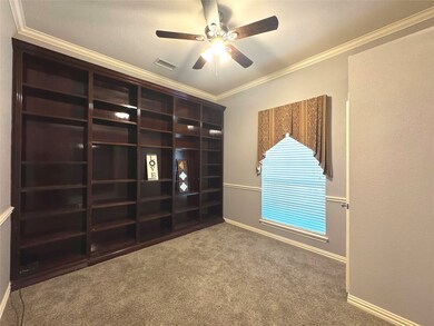 Spare room with crown molding, carpet floors, and a ceiling fan