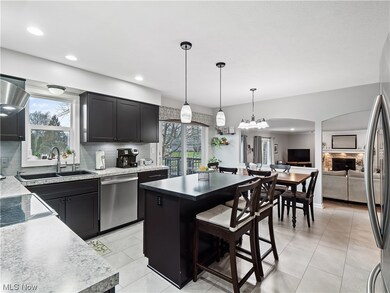 Kitchen featuring updated light fixtures, stainless steel appliances, center island, and tasteful backsplash