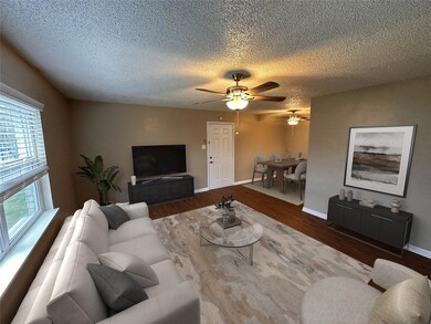 Living room featuring a textured ceiling, baseboar