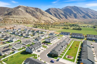 Aerial view of property and surrounding area featuring nearby suburban area and mountains