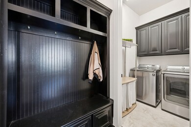 Garage leads into MUD and Laundry area featuring tall cabinets for extra storage