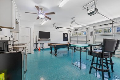 Rec room with a sink, a garage, speckled floor, an