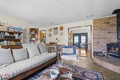 Living area with a wood stove, visible vents, a te