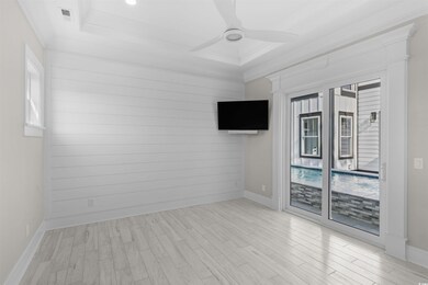 Empty room with ceiling fan, crown molding, wood f