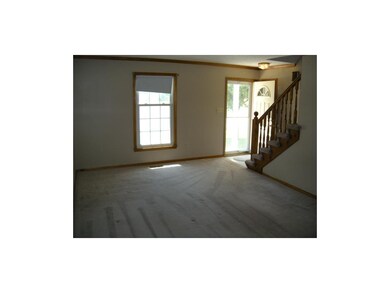 Living room view to the front door and stairs.