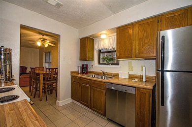 Kitchen with light tile patterned flooring, applia