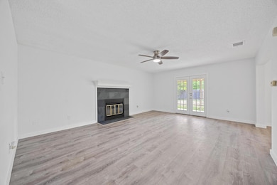 Unfurnished living room featuring a ceiling fan, 