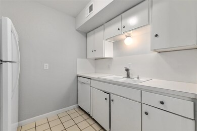 Kitchen featuring light countertops, a sink, whit