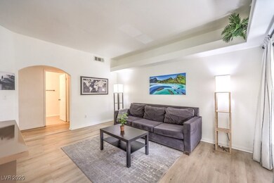 Living room featuring arched walkways and light wo