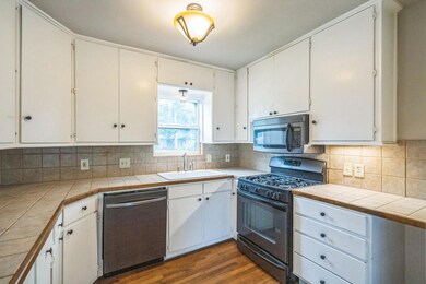Kitchen with stainless steel appliances, dark woo