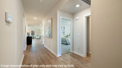 Hallway with light wood-style floors and recessed lighting