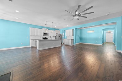 Unfurnished living room with ceiling fan, dark har