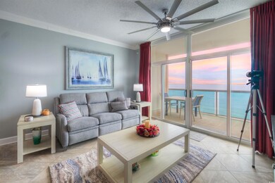 Living area with a water view, a textured ceiling, ornamental molding, a ceiling fan, and light tile patterned flooring