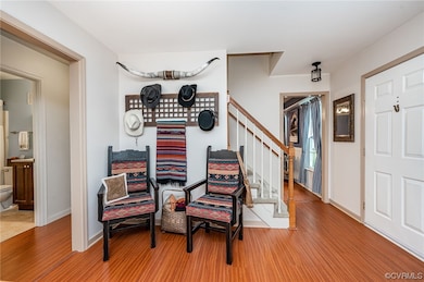 Living room with view of hall bath, hallway, stair
