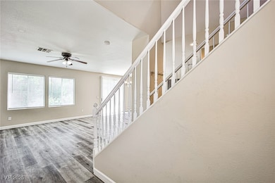 Stairway with a ceiling fan, wood finished floors,