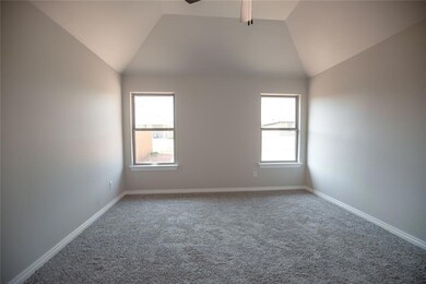 Empty room featuring ceiling fan, vaulted ceiling,