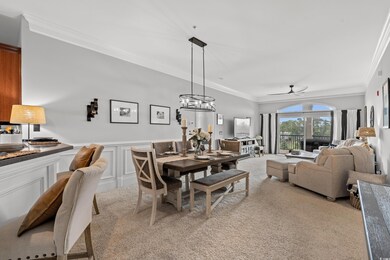 Dining space with a wainscoted wall, a decorative wall, light colored carpet, and crown molding