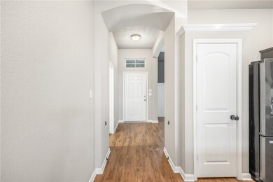 Corridor with wood finished floors, baseboards, an