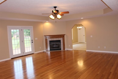 Living Room has trey ceilings, Recessed lighting, gas fireplace, & french doors to back deck