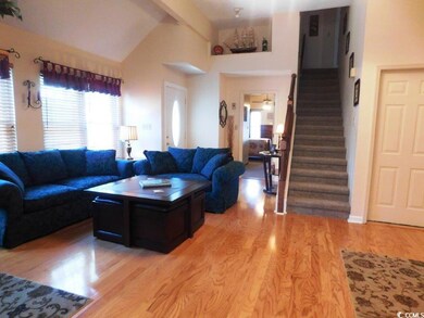 Living area with vaulted ceiling with beams, light