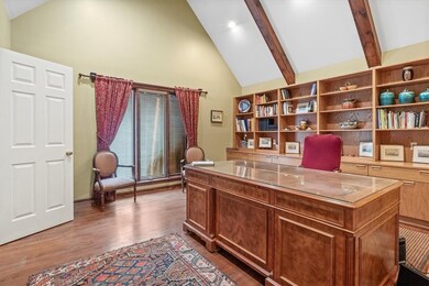 Spacious Den with beamed ceiling and door to the o