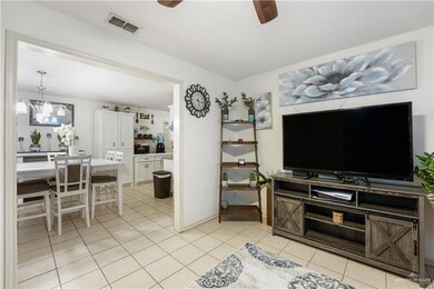 Living area featuring a chandelier, ceiling fan, and light tile patterned flooring