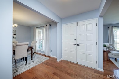 Foyer featuring wood finished floors and a chandelier