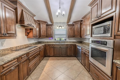 The kitchen features solid wood cabinetry, built in stainless steel convection oven and microwave, dishwasher, electric cooktop and granite countertops.
