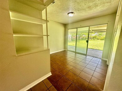 Tiled spare room with visible vents, a textured ce