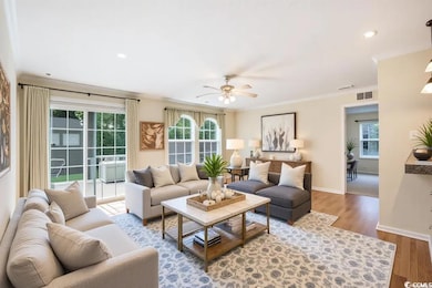 Virtually staged Living area with wood finished floors, plenty of natural light, a ceiling fan, crown molding.