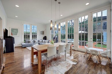 Bright and airy den with a soaring ceiling and a wall of floor to ceiling French doors that provide an abundance of natural light in the home and great views into the beautiful backyard. Recessed and pendant lighting is a nice touch!