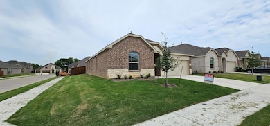 View of front of home featuring brick siding, driv